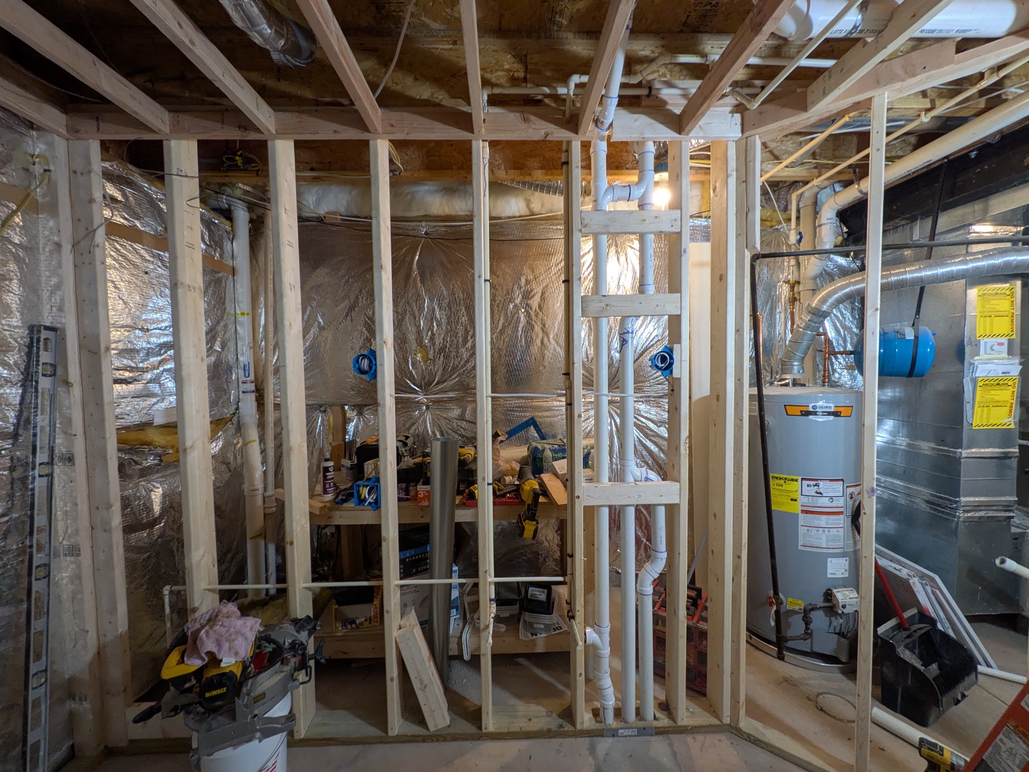 The room framed, with vapor barrier and plumbing stack
