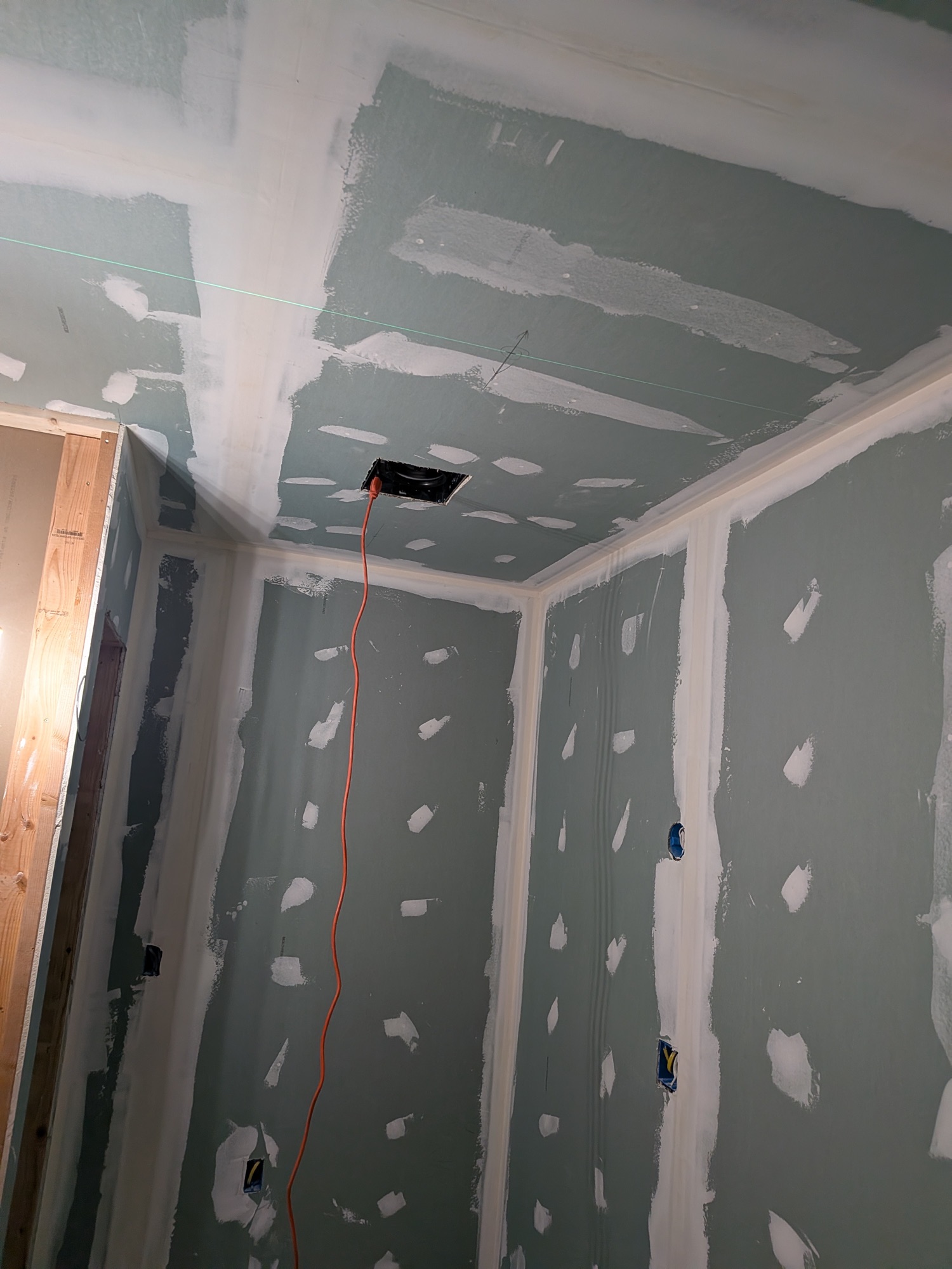 Moisture-resistant board taped and mudded, recessed lighting cut in
